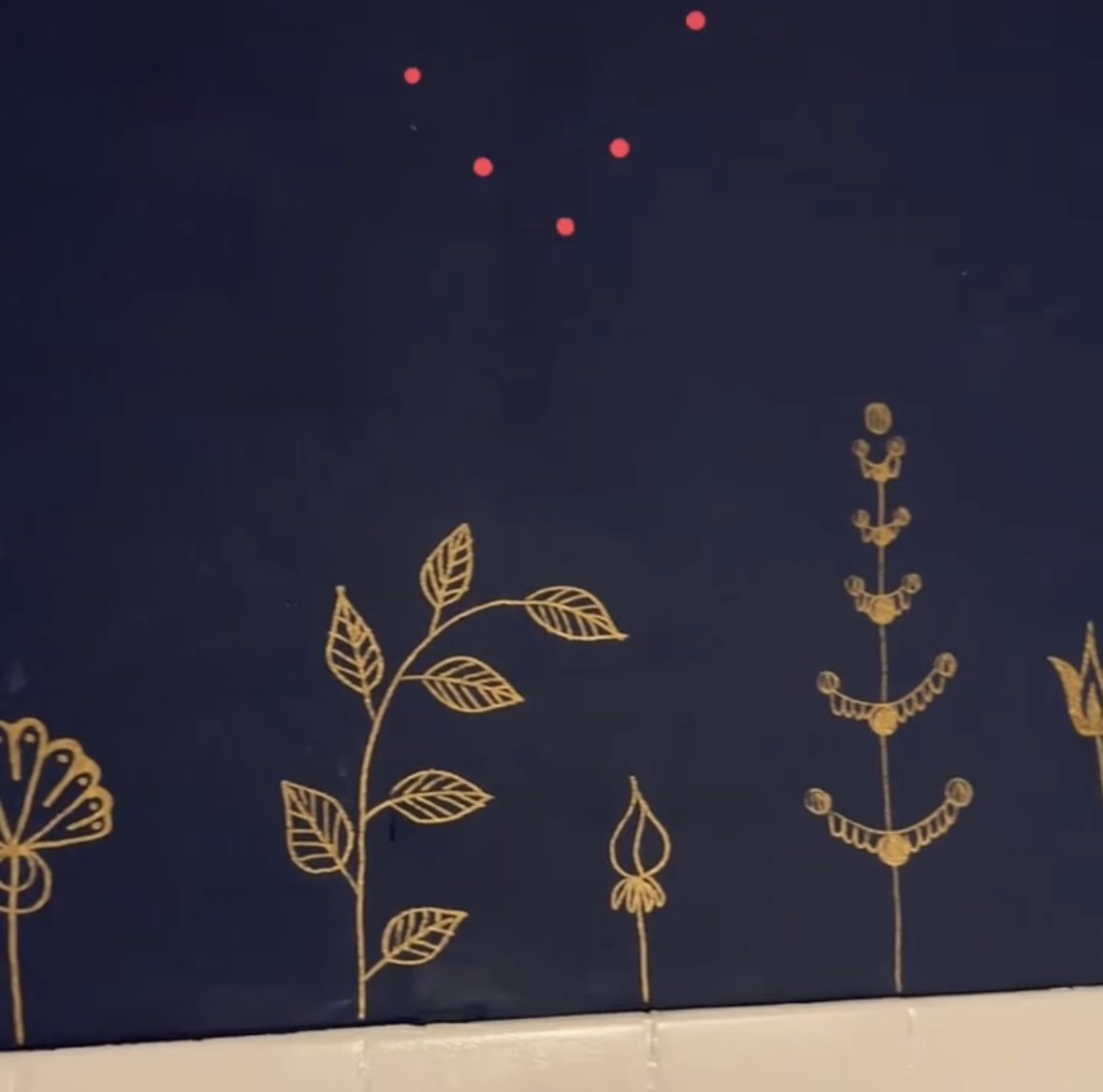 Handgemalte goldene Blumen auf dunkler Wand